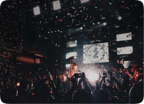 Concert with a band performing, bright lights, and falling confetti